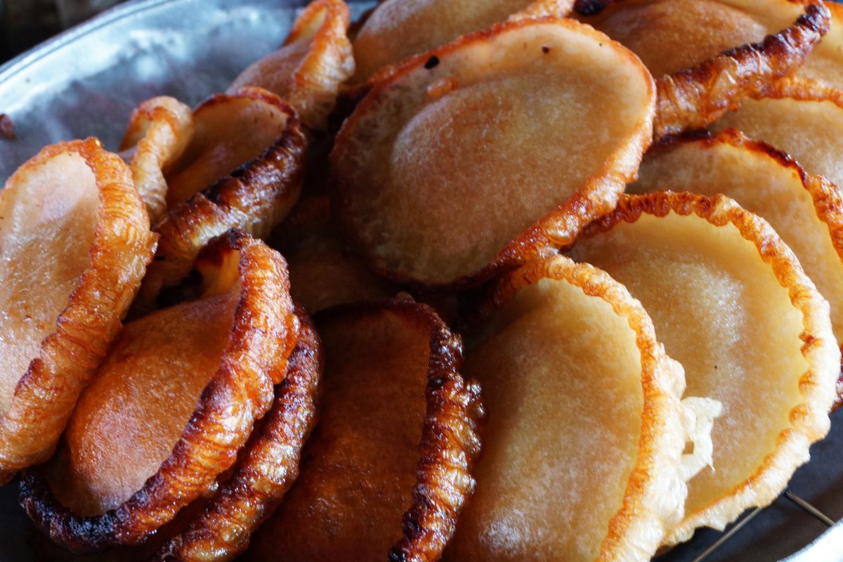 Golden fried traditional Malaysian kuih on a metal tray at a street stall, Sabah, Malaysia