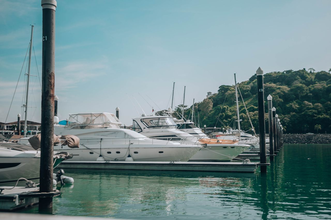 Yachts moored at a Langkawi marina with forested hills behind